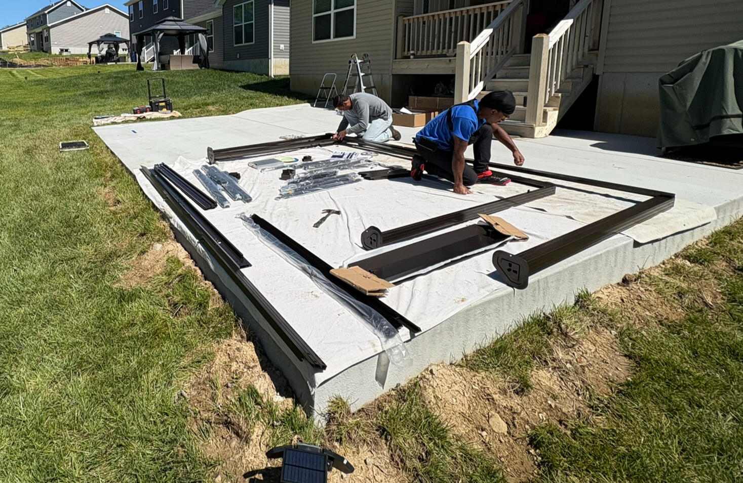 We start by laying down a protective drop cloth to keep materials clean and organized. Chalk lines are snapped for precise placement, and every post is set plumb, square, and level before anchoring begins — ensuring a clean, professional finish from the gr